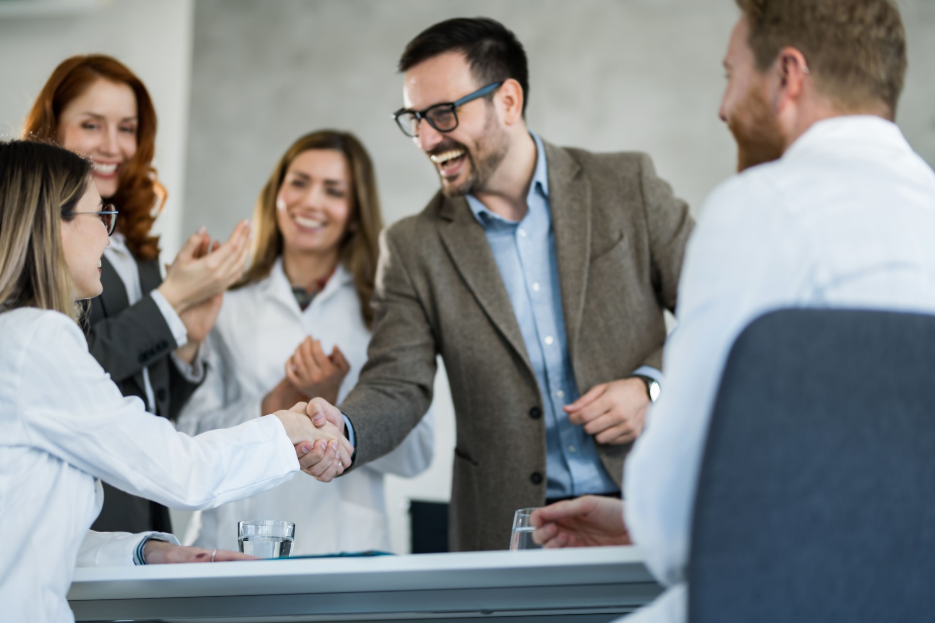 Business people having a meeting with doctors in the office and shaking hands.